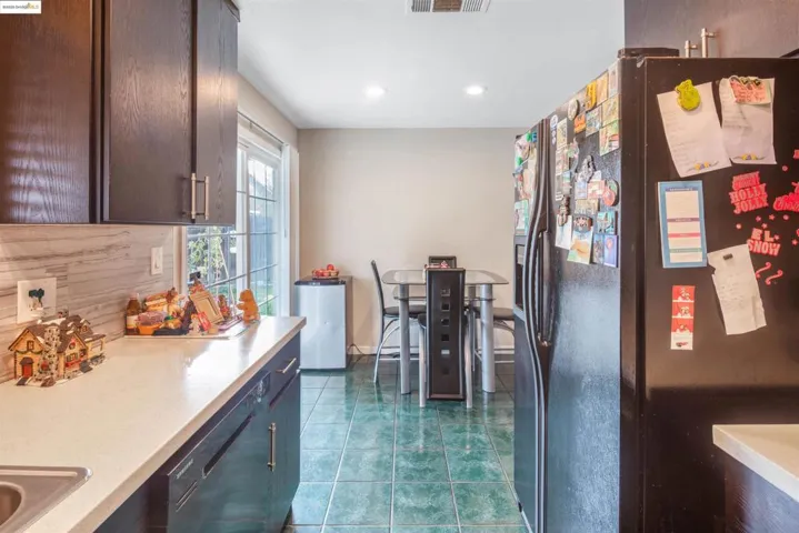 Kitchen with black appliances, dark tile patterned flooring, recessed lighting, backsplash, and dark brown cabinetry