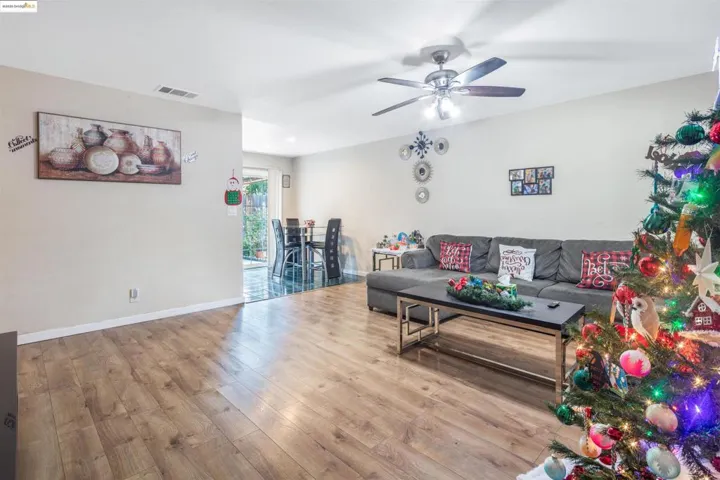 Living area with hardwood / wood-style flooring and a ceiling fan
