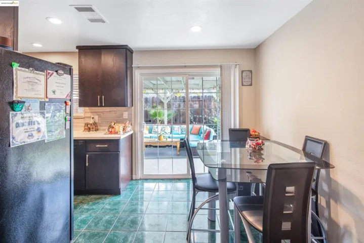 Dining room with dark tile patterned flooring and recessed lighting