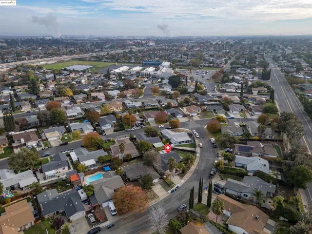 Aerial view of property and surrounding area featuring nearby suburban area