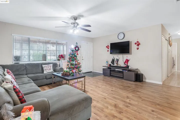 Living area featuring light wood-style floors and ceiling fan