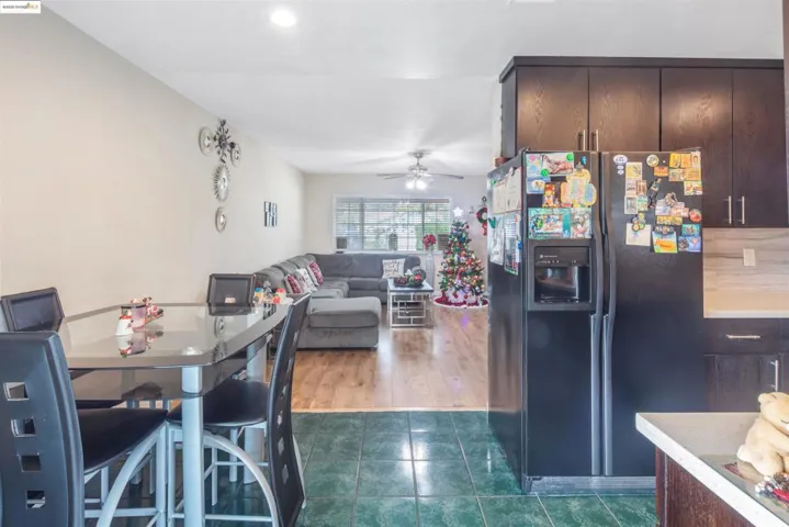 Dining space with ceiling fan and dark tile patterned flooring