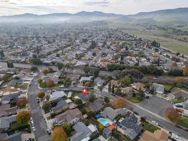 Aerial view of property and surrounding area with nearby suburban area and a mountain backdrop