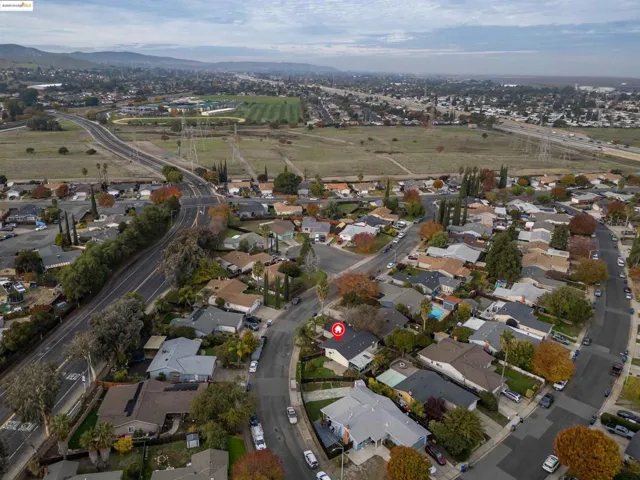 Aerial view of property and surrounding area featuring nearby suburban area