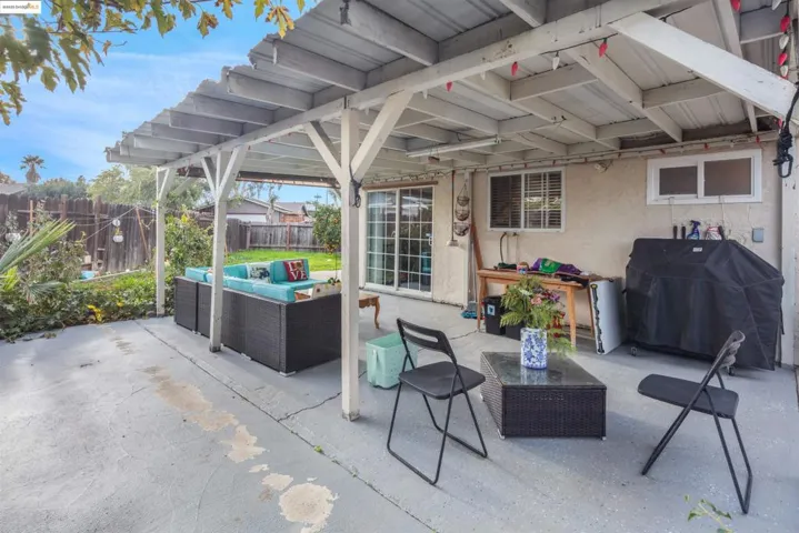 Fenced backyard featuring an outdoor living space, grilling area, and a patio
