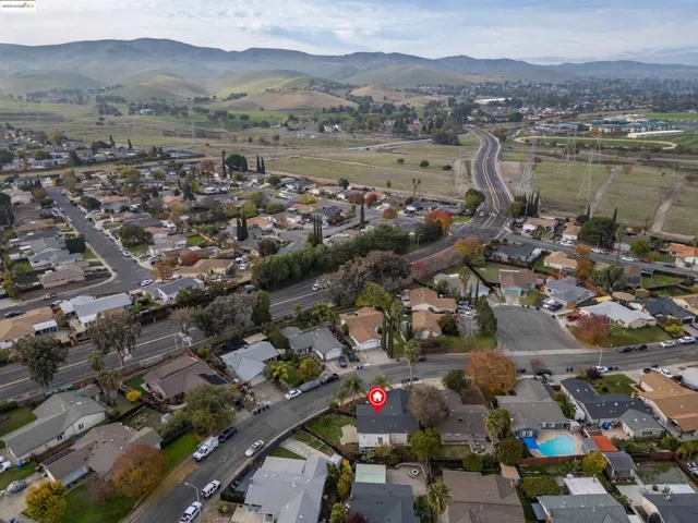 Aerial view of property's location with nearby suburban area and a mountain backdrop