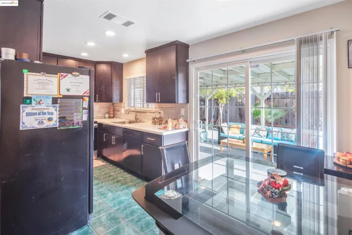 Kitchen with black appliances, decorative backsplash, recessed lighting, dark brown cabinets, and dark tile patterned floors