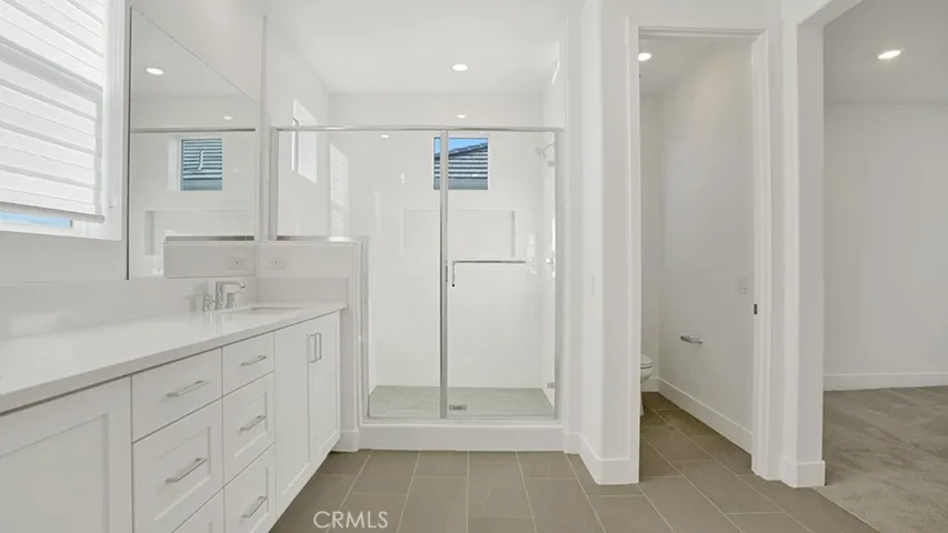 Different angle of the Primary Bathroom and private water closet.  Notice the LARGE shower with windows to bathe you in warm natural light.