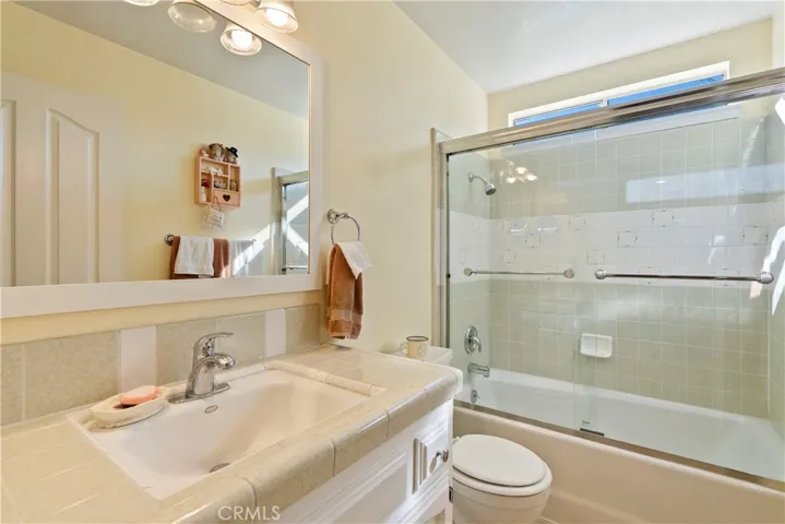The main bathroom has a tiled tub/shower combination and a tile topped vanity.