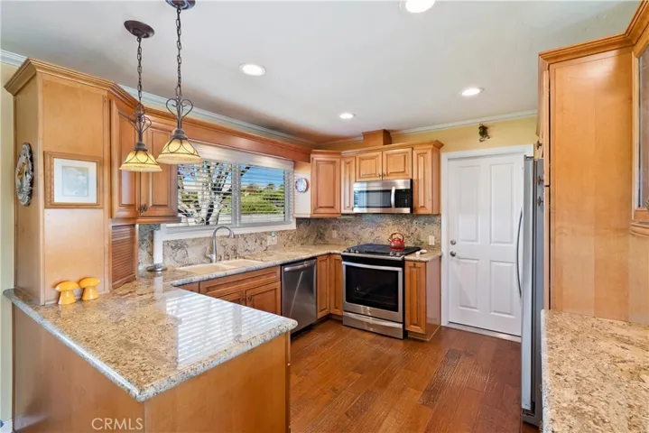 The updated kitchen boasts abundant cabinets for storage and wood floors.