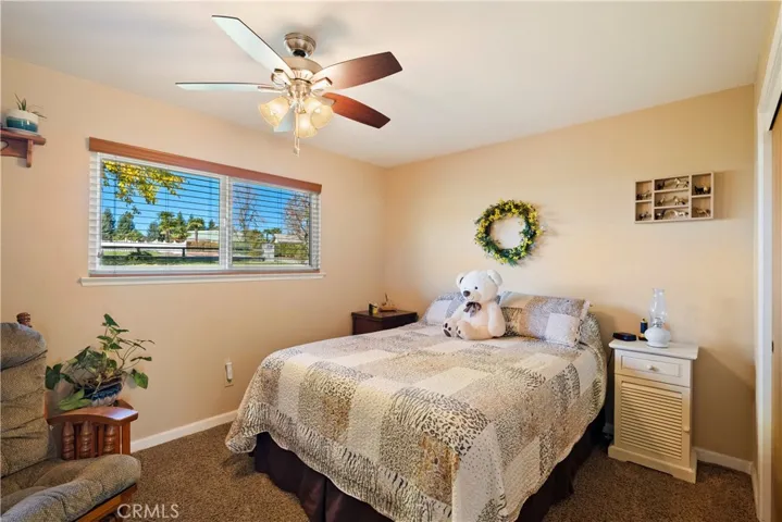 On the opposite side of the home we find the bedrooms and bathrooms. Bedroom 2 has carpet, a ceiling fan and view of the front yard.