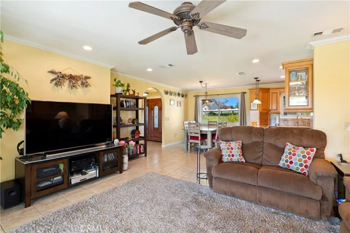 The family room has recessed lighting, ceiling fan, crown molding and tile floors. It flows nicely into the dining area and kitchen for a cohesive feel.