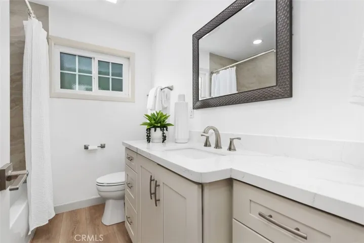 Full remodeled bath and includes tub with shower overhead,plus attractive new cabinetry, quartz countertop, and new toilet~