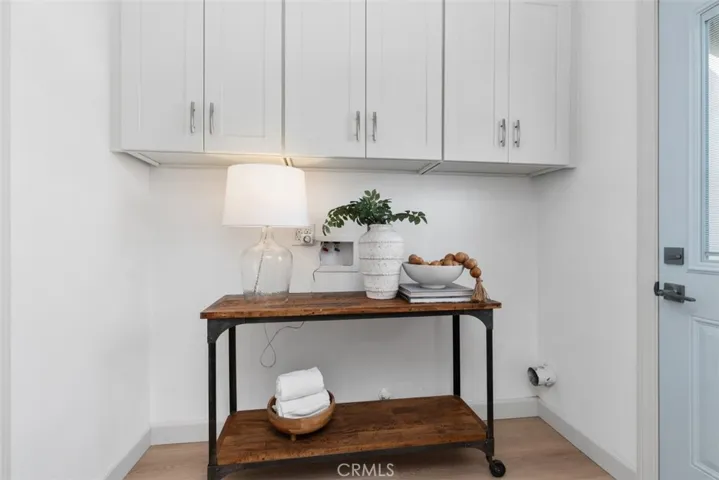 Indoor laundry area with overhead storage cabinets and new back door to the outside~