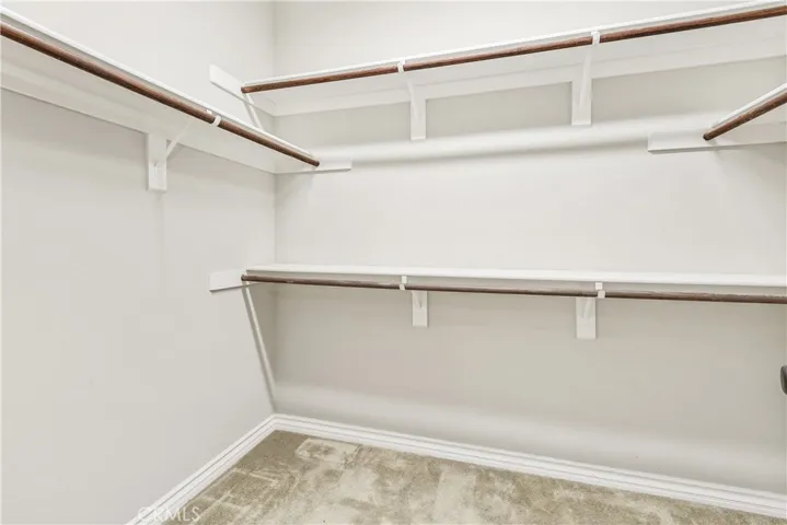 2 separate walk-in closets in the hallway of the primary suite.