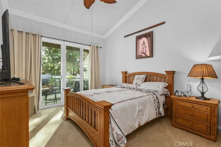 Primary Bedroom with access to attached deck. Soaring ceilings and crown molding.