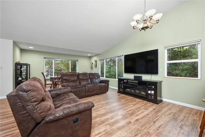 Living area and dining area are open and welcoming with vaulted ceilings.