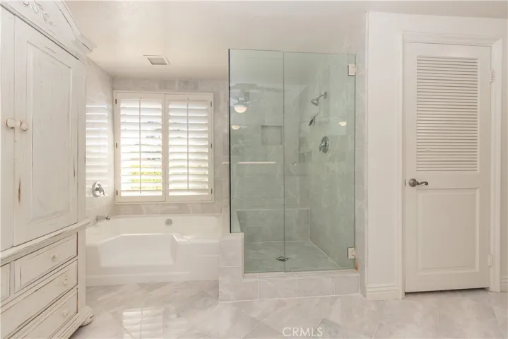 Soaking tub and glass enclosed shower in the primary bath.