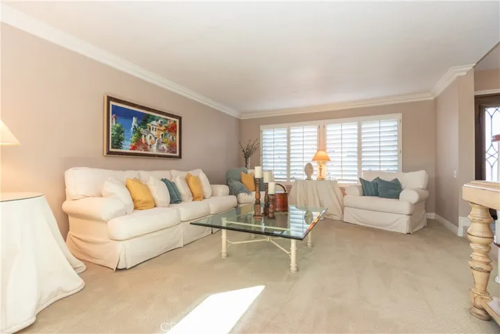 Plush carpet, crown molding and plantation shutters in the living room.