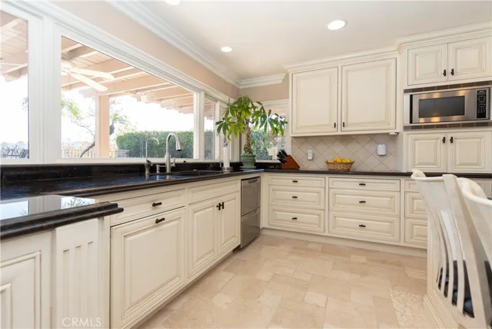 Granite counters and handsome cabinetry, plus a window to the backyard view in the kitchen.