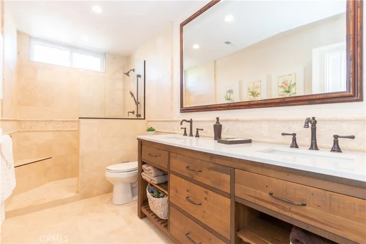Hall bath has a freestanding dual vanity and walk-in shower.