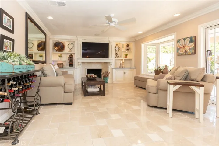 Comfortable family room has a central fire place and media wall.