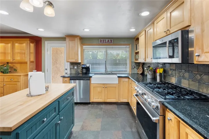 gas range stove with granite counters tons of cabinet storage. tile flooring stainless appliances