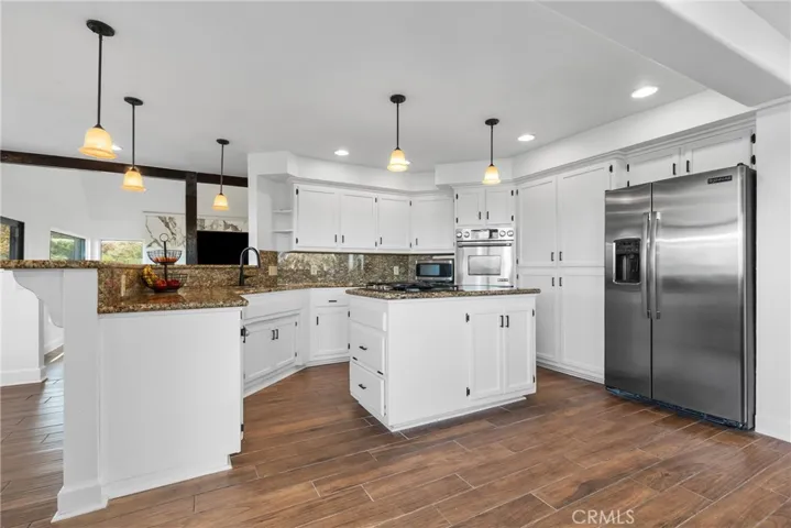 The kitchen features granite countertops and stainless steel appliances. Bonus, the refrigerator stays!