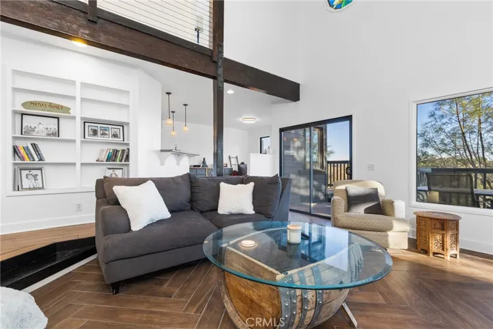The living room has built-in shelves next to the fireplace and also on the back wall.