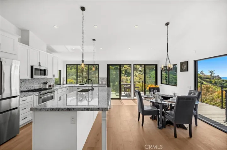 Inside, a beautifully arranged dining, kitchen, and family area is designed for both elegance and ease.