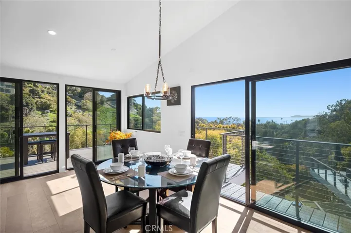 Vaulted ceilings and brand-new Milgard windows frame sweeping views, extending from the fireplace-warmed living room to the coastal-view dining space—an ideal setting for entertaining.
