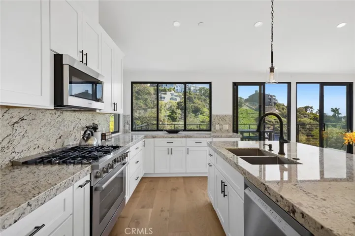  The chef’s kitchen is both functional and refined, featuring stone countertops, custom cabinetry, and a center island with charming breakfast seating.