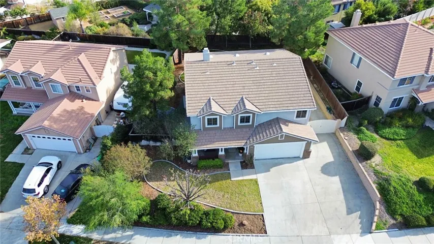 Aerial view of the front of the home, showcasing the driveway, landscaped yard, and inviting curb appeal.