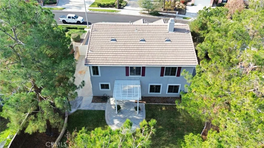 Aerial view of the spacious, landscaped backyard, highlighting the patio, RV slab, and ample outdoor space for entertaining and recreation.