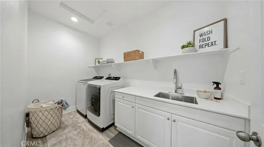 Inside dedicated laundry room with storage and sink - Virtually Staged