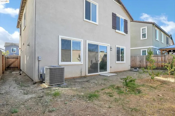 Back of house featuring a fenced backyard and stucco siding