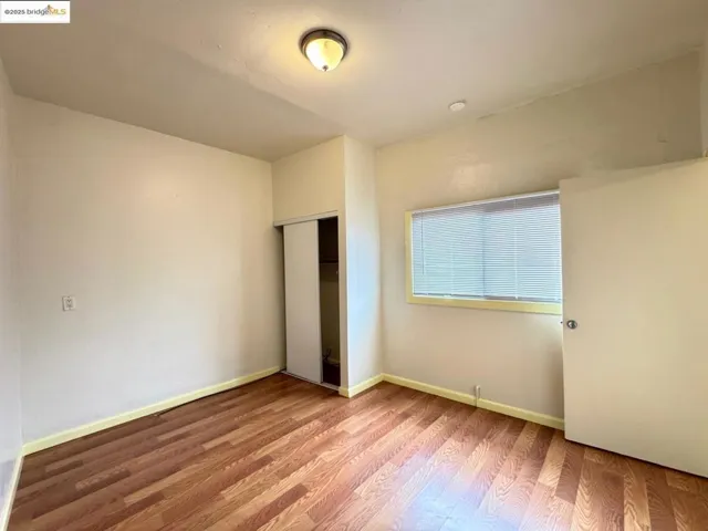 Unfurnished bedroom featuring light wood-style flooring and a closet