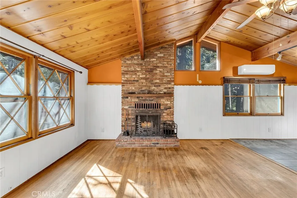 Living room has hardwood floors and beautiful brick fireplace