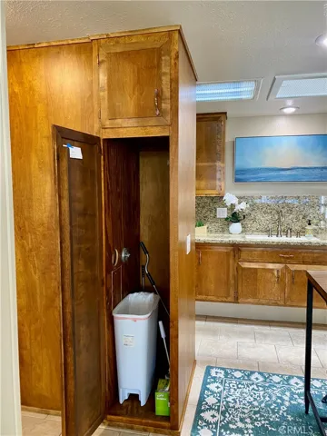 BROOM CLOSET AND TILED FLOORING IN THE KITCHEN