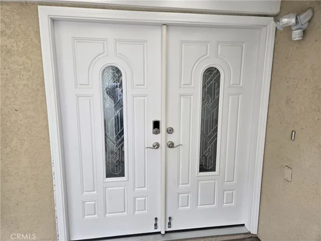 Beautiful double-door entry with glass panels and storage lockers to left
