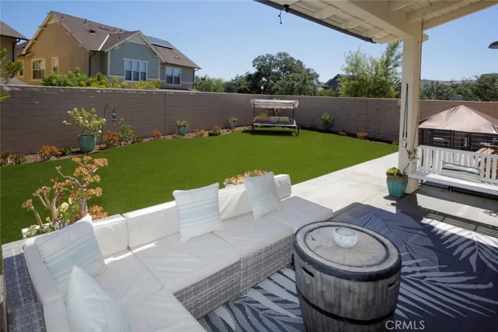 Covered patio overlooking the expansive pool size yard.