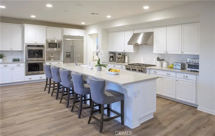 Chef’s kitchen featuring an oversized island and high-end KitchenAid stainless steel appliances.