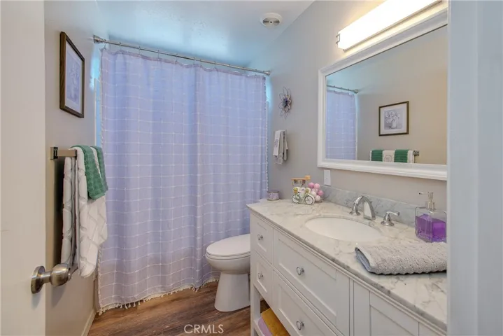 Beautifully remodeled hall guest bath with wood type laminate floors.