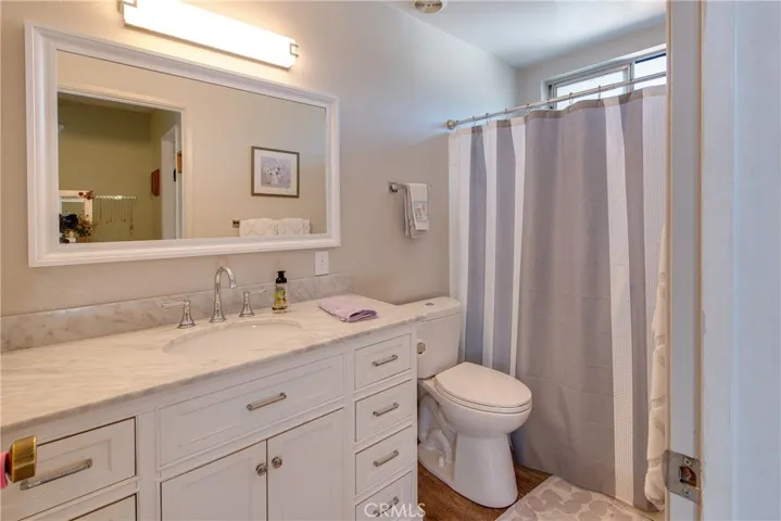 Beautiful remodeled master bathroom with wood type laminate floors.