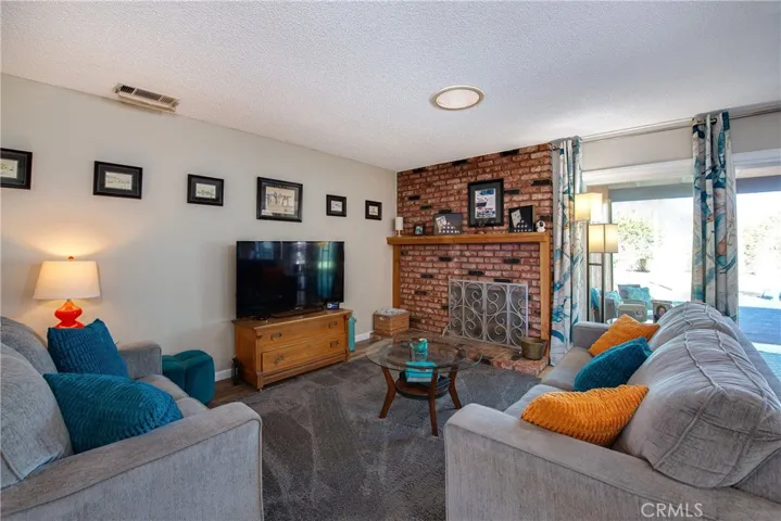  Stunning bright living room with a floor-to-ceiling brick fireplace.