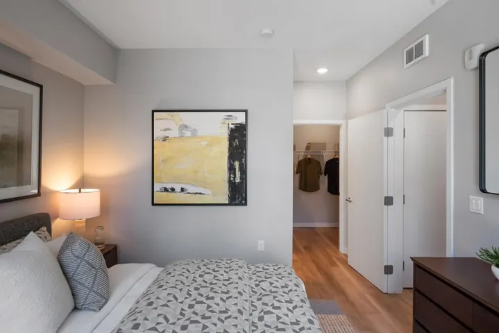 Bedroom featuring a spacious closet, light wood finished floors, and recessed lighting