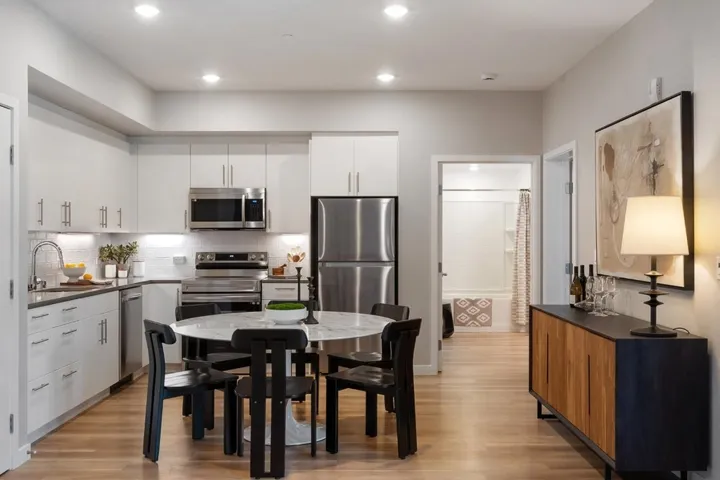 Kitchen featuring backsplash, appliances with stainless steel finishes, light wood-type flooring, white cabinetry, and recessed lighting