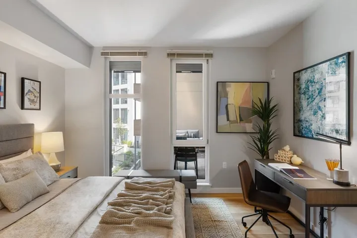 Bedroom featuring wood finished floors and an office area