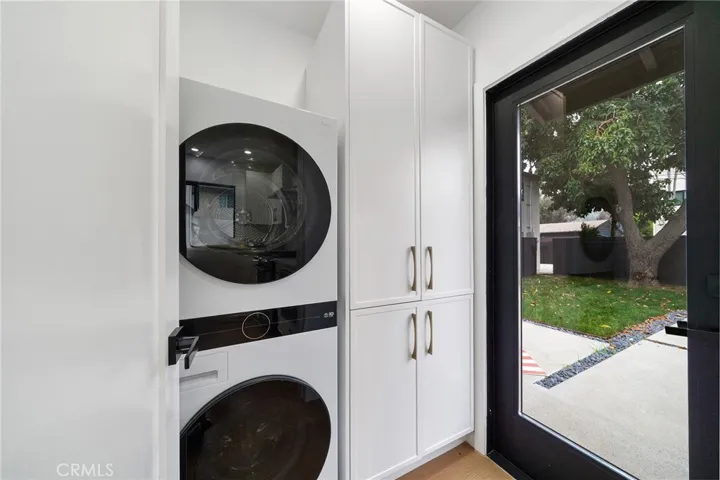 2229 Shoredale Stackable laundry with natural light from the exterior glass door.