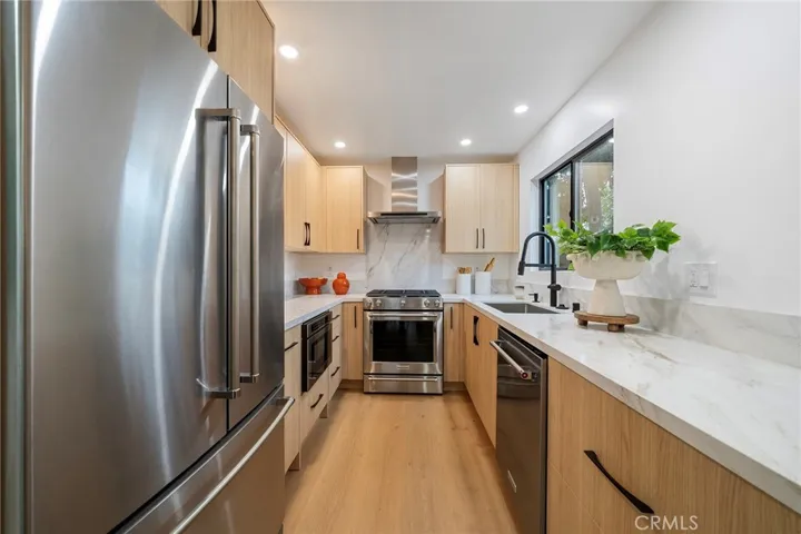 2225 Shoredale gorgeous galley kitchen with quartz counters and appliances to remain: refrigerator, cabinet drawer microwave, dishwasher, gas stove.